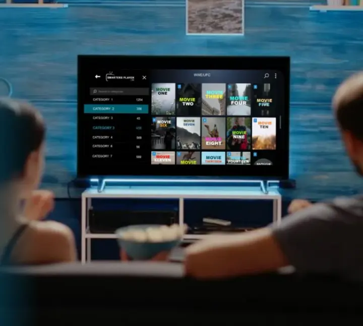 Couple watching Xtreme HD IPTV on a living-room TV with popcorn